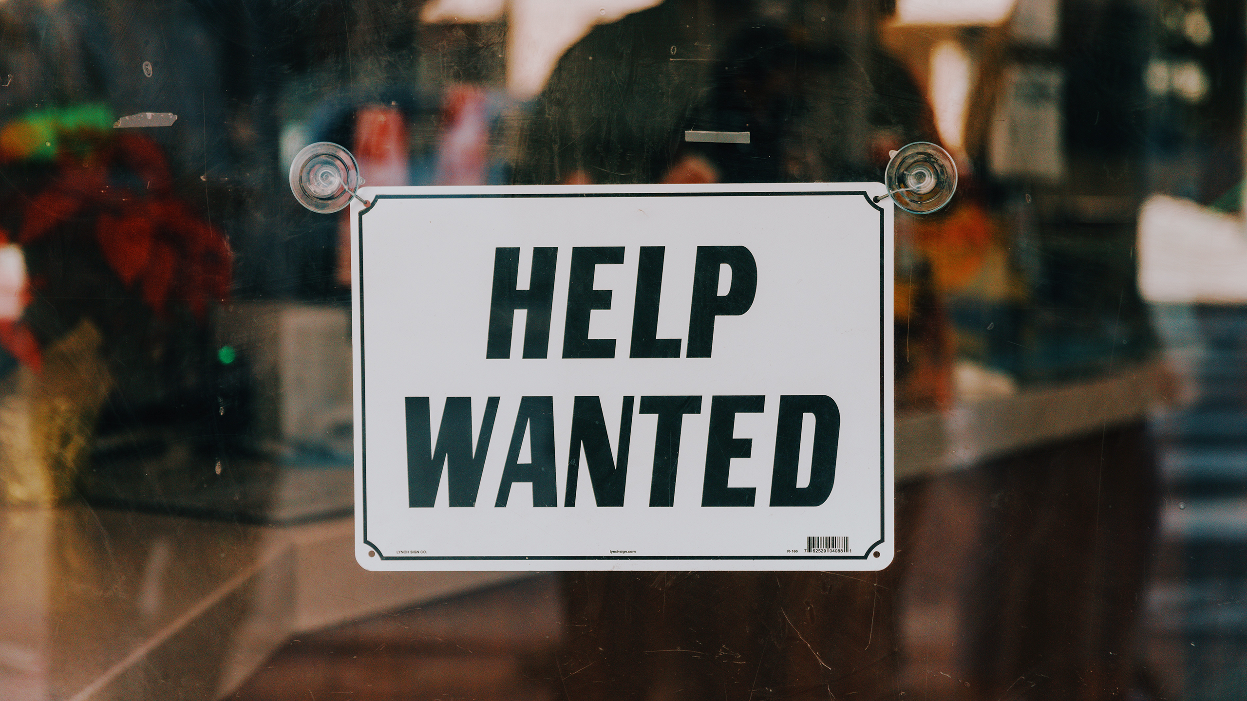 Photo of a help wanted sign on a window