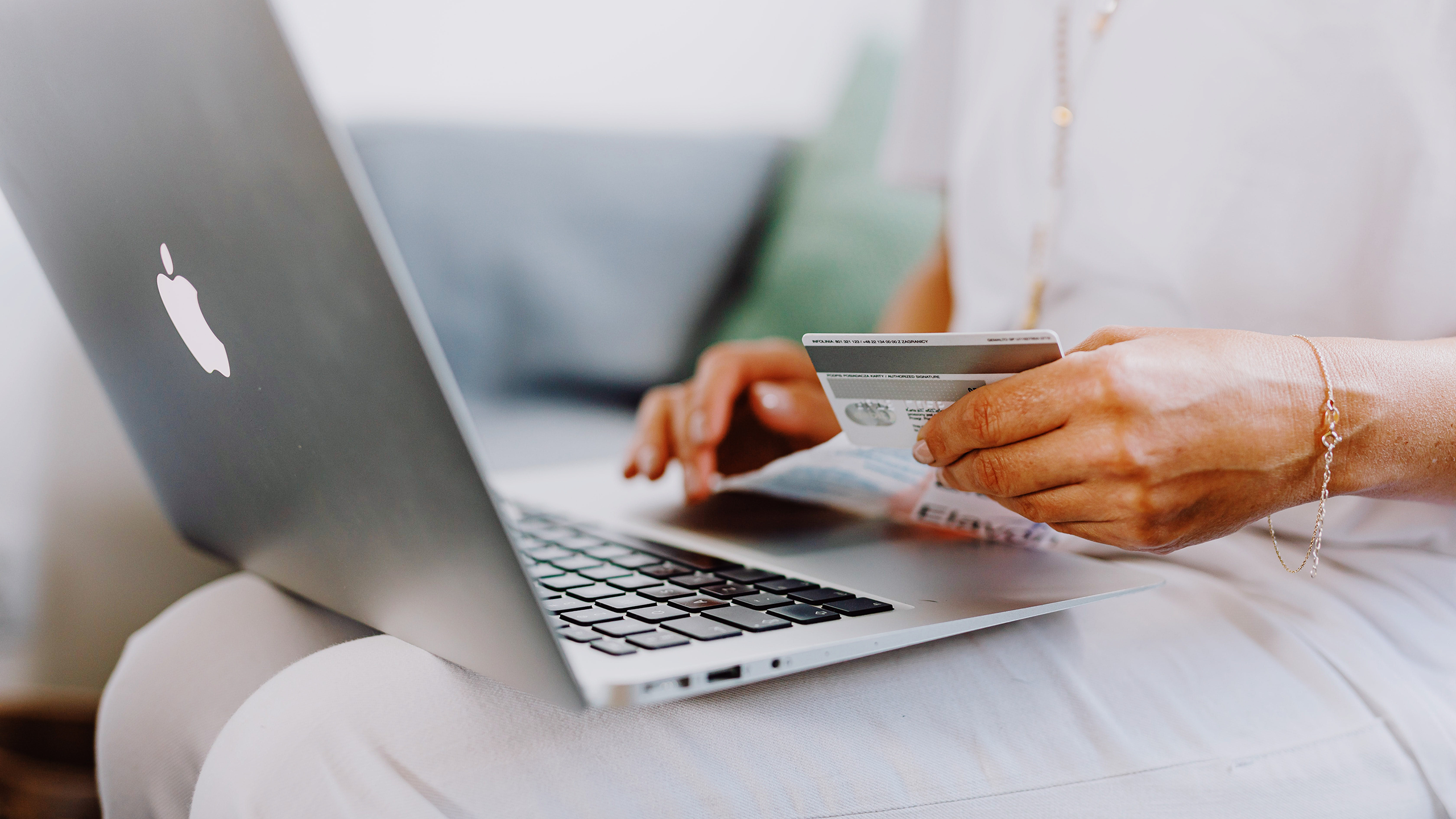 Photo of a person online shopping and holding a credit card