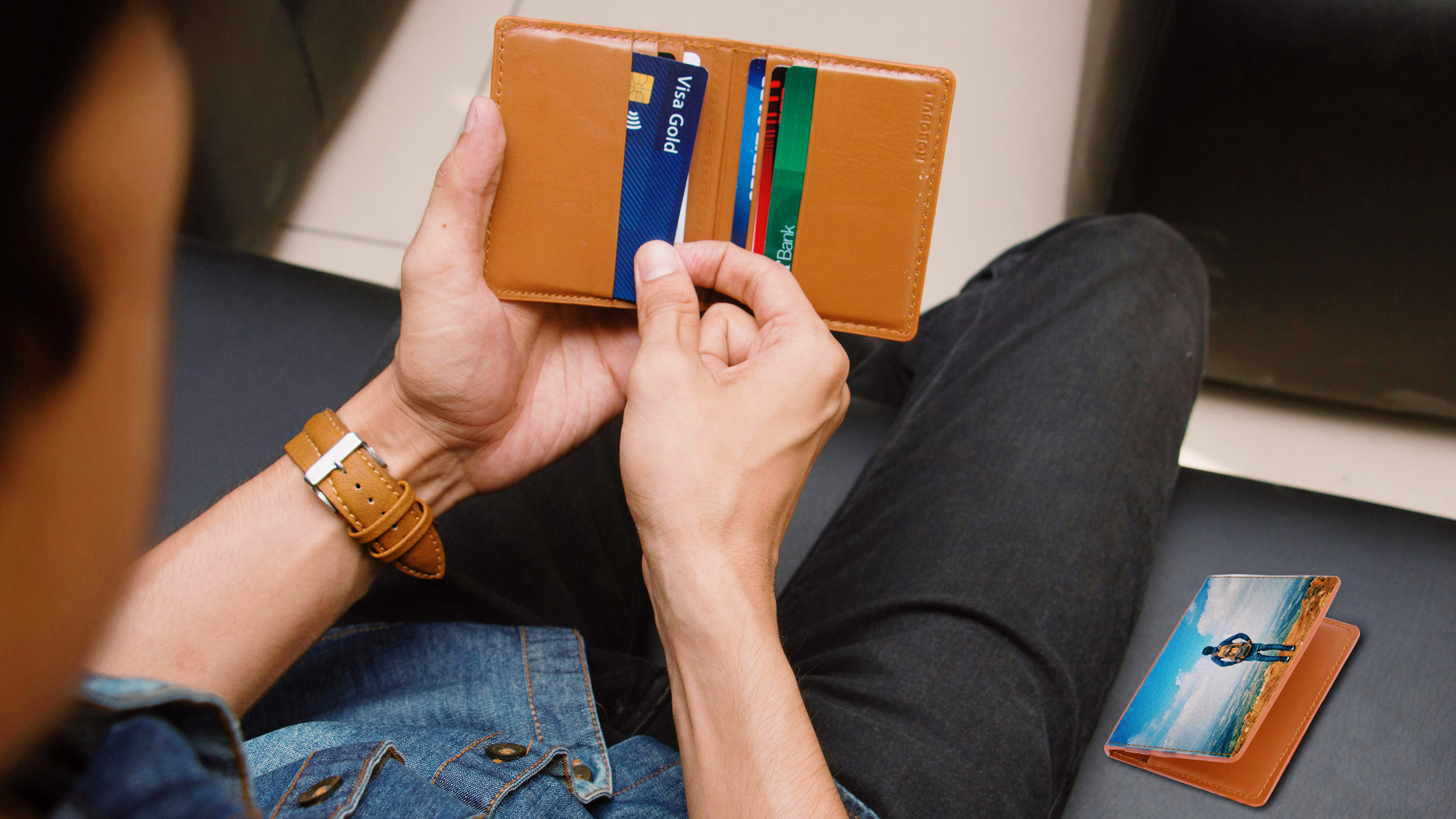 Photo of a person holding a wallet full of credit cards