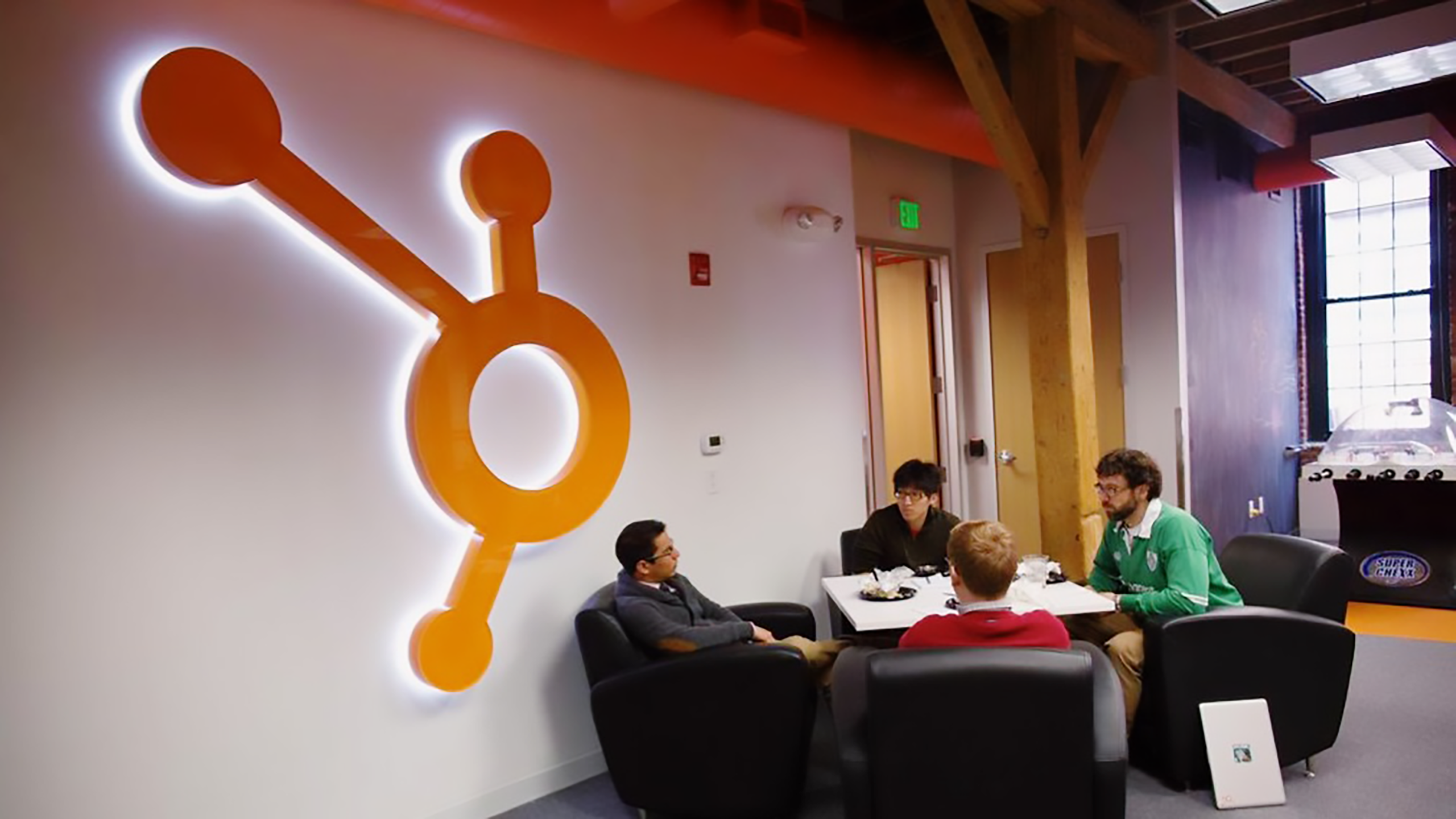 Photo of employees sitting around a table in a HubSpot office