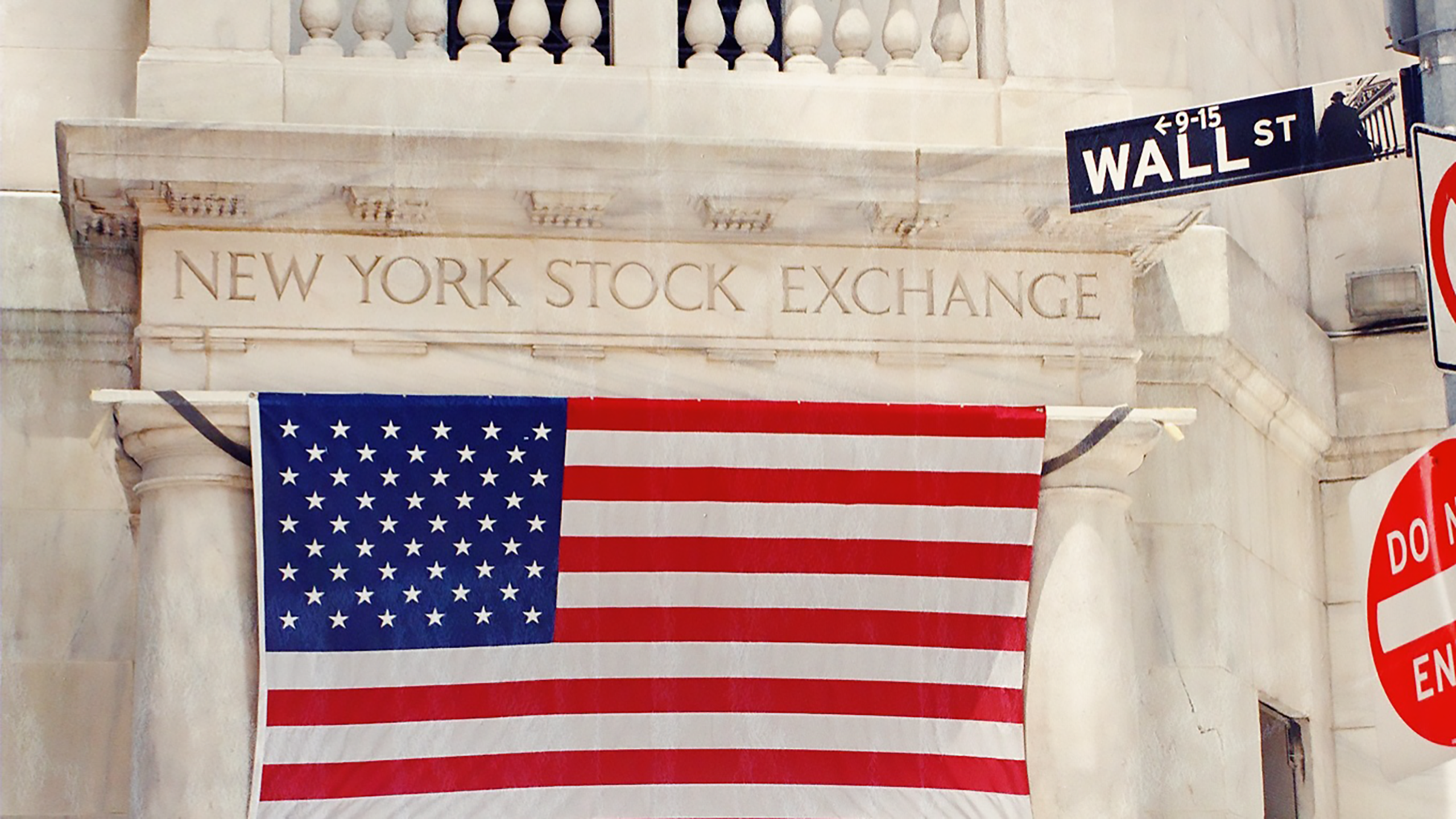 Photo of New York Stock Exchange building and Wall Street sign