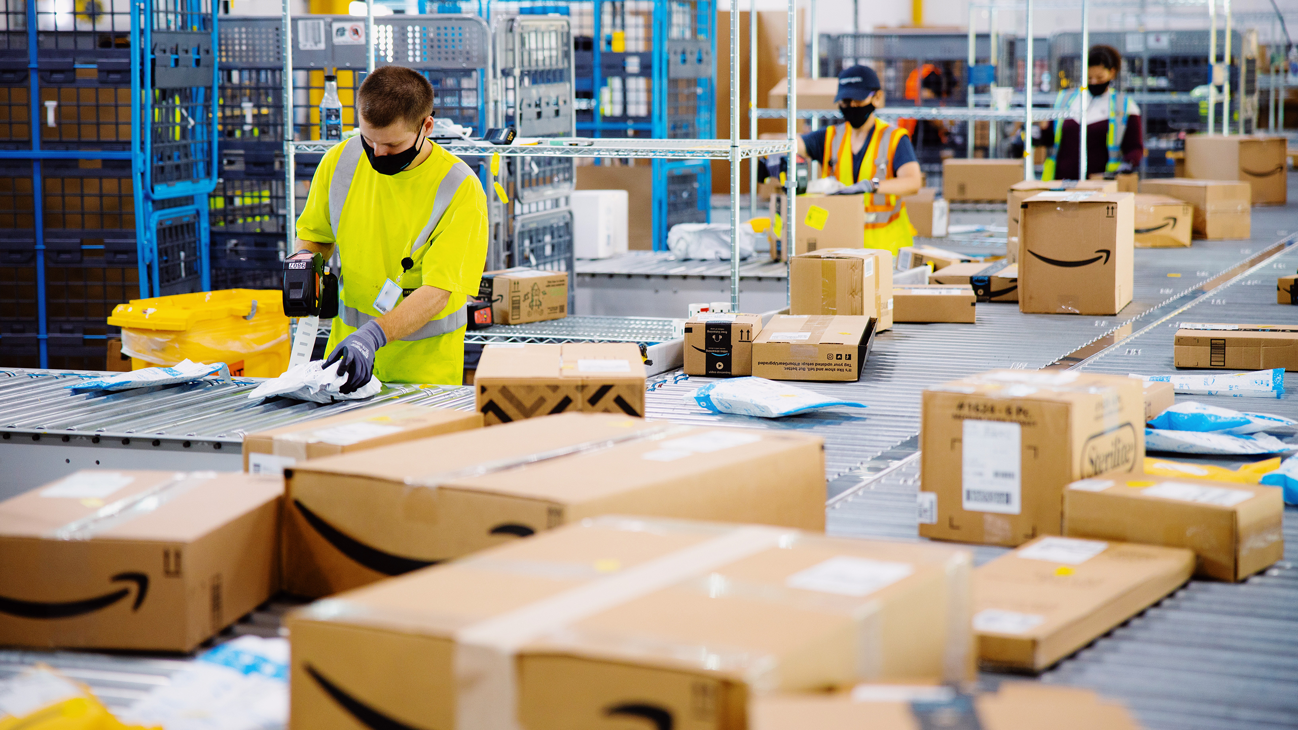 Photo of Amazon employees in a warehouse sorting packages
