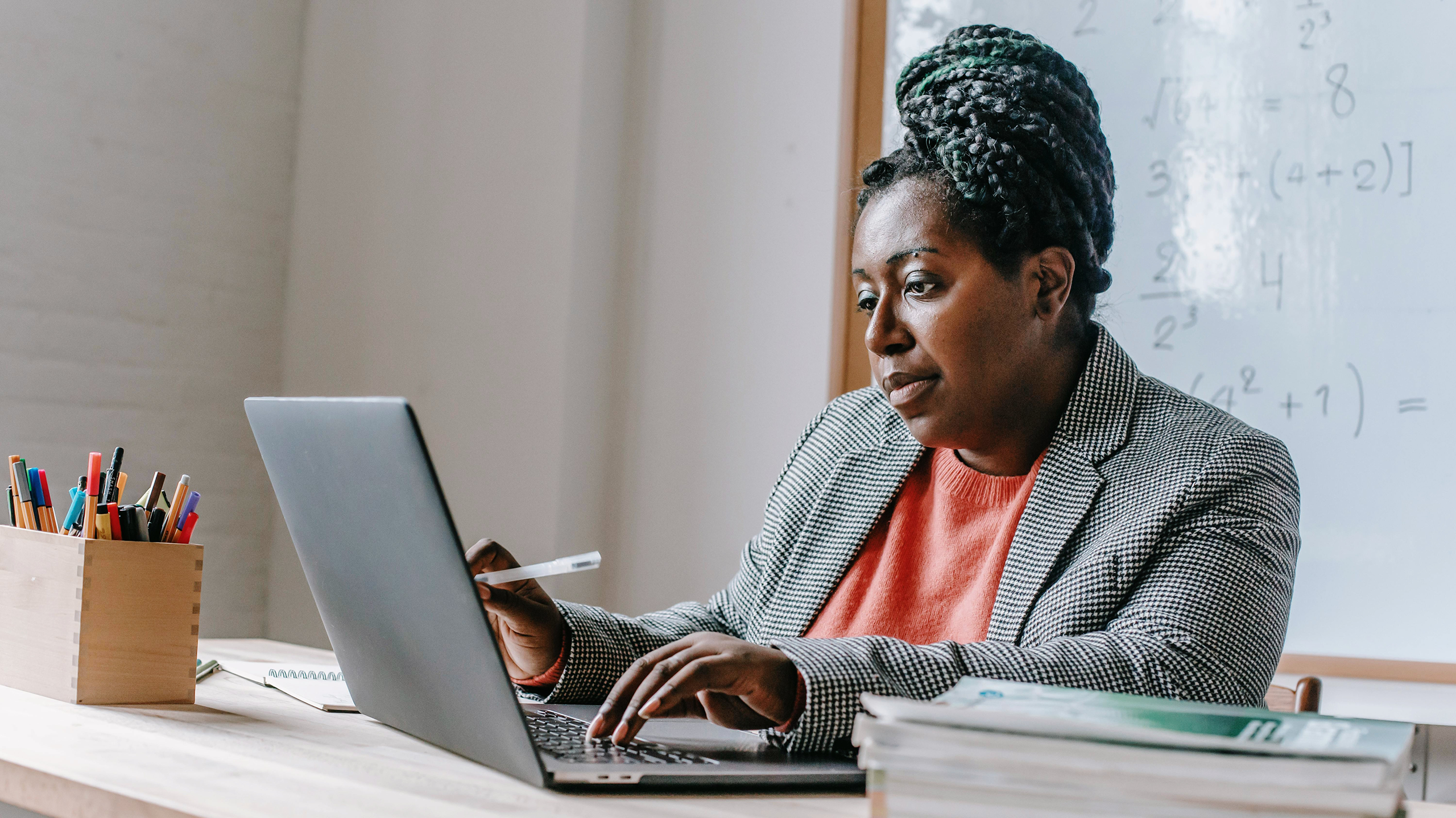 Photo of a woman looking at a laptop screen in a classroom