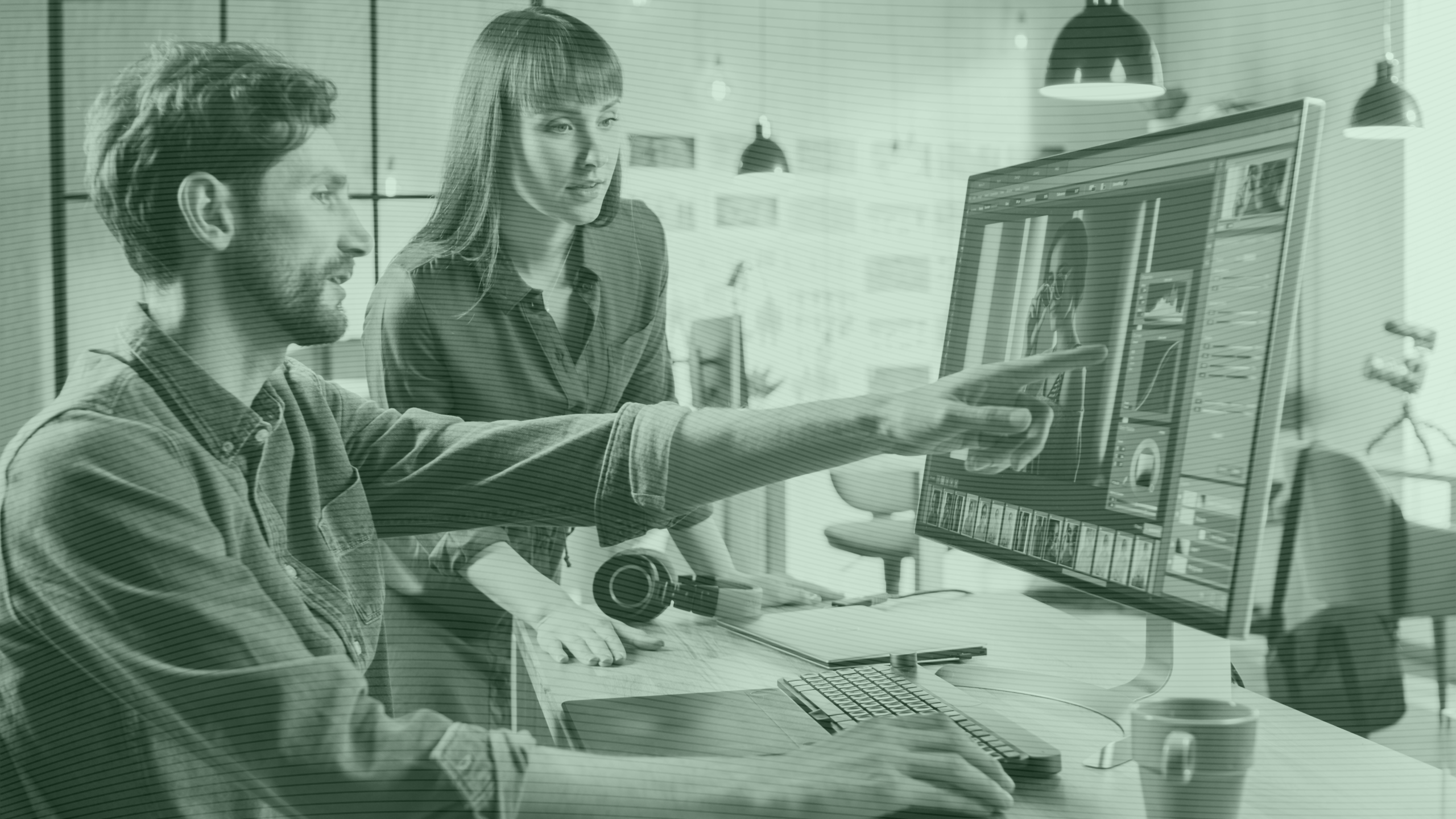 Photo of two colleagues using Photoshop on a computer