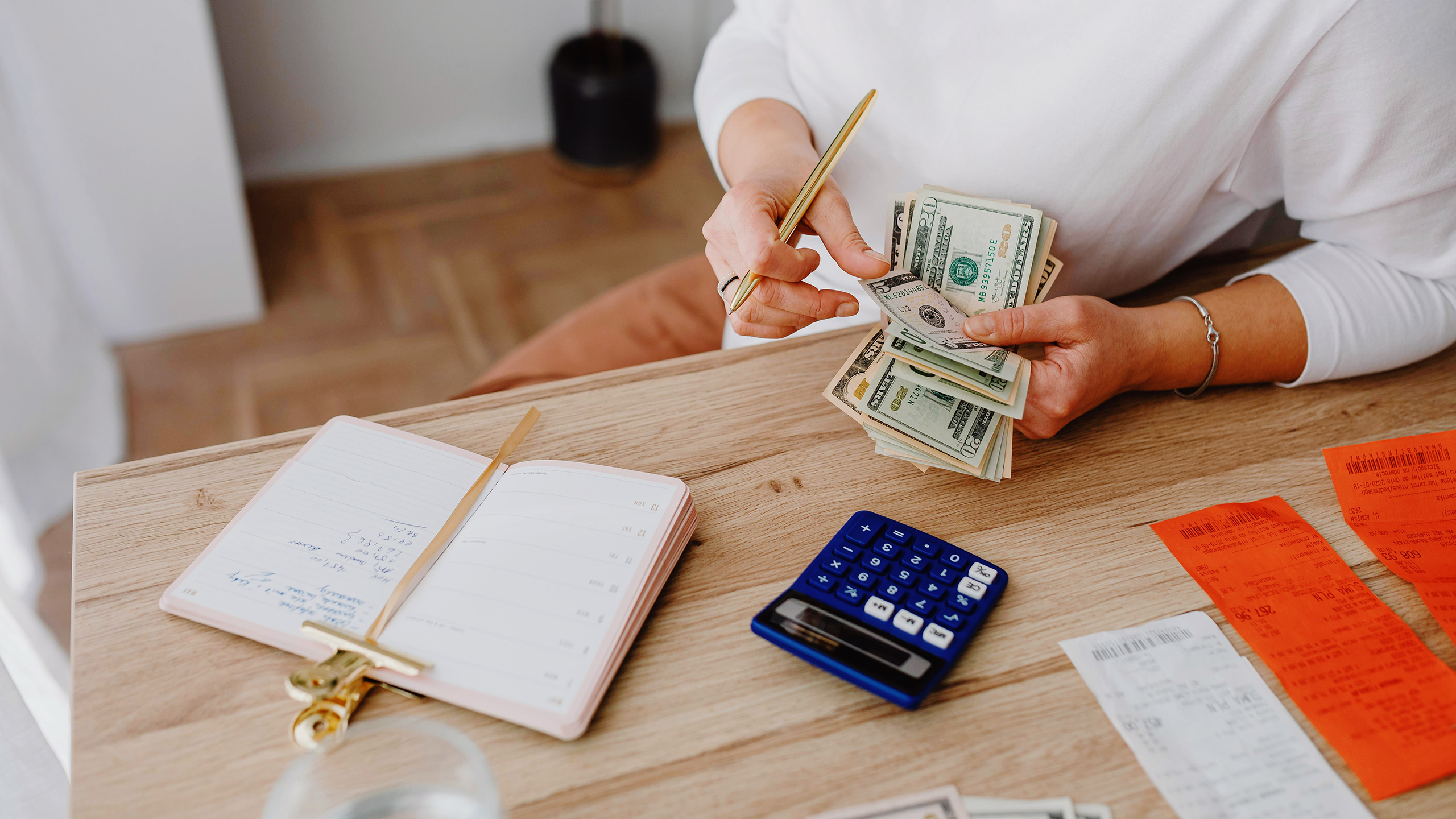 Photo of a person calculating expenses with a calculator and receipts