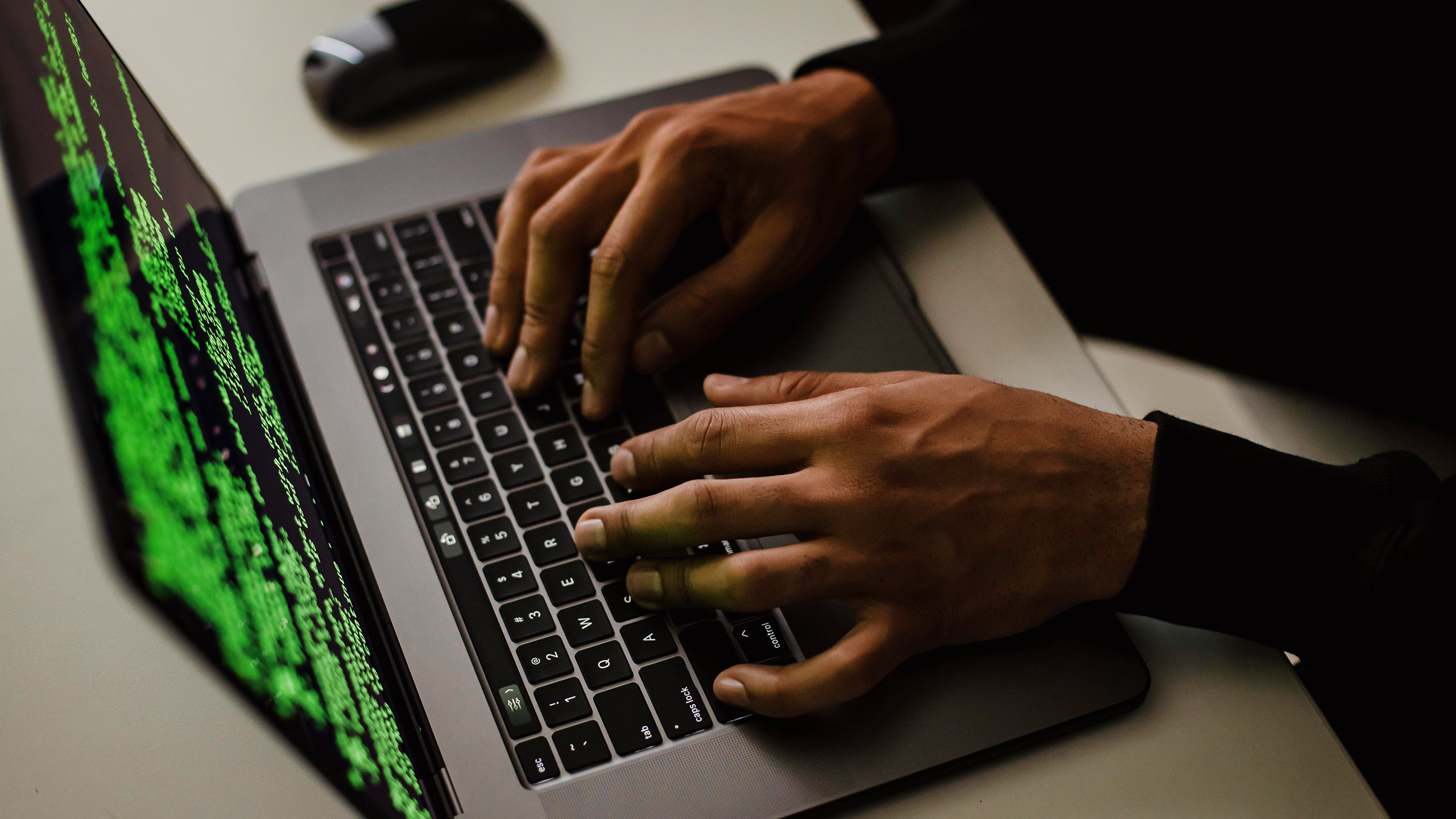 Photo of a person using a laptop screen with code on it