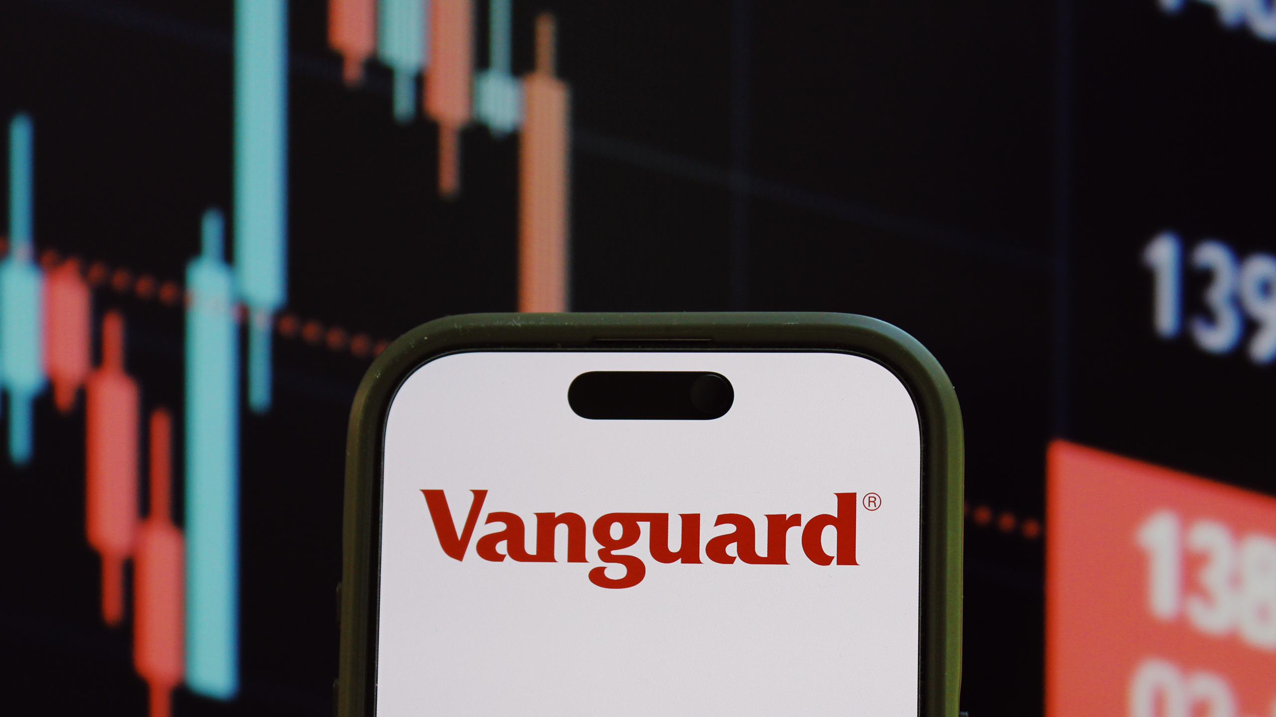 Photo of the Vanguard logo in front of stock charts