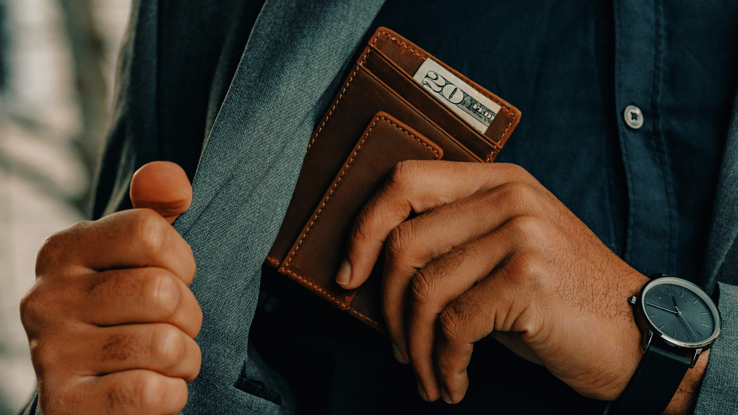 Photo of a person putting wallet and cash into a pocket