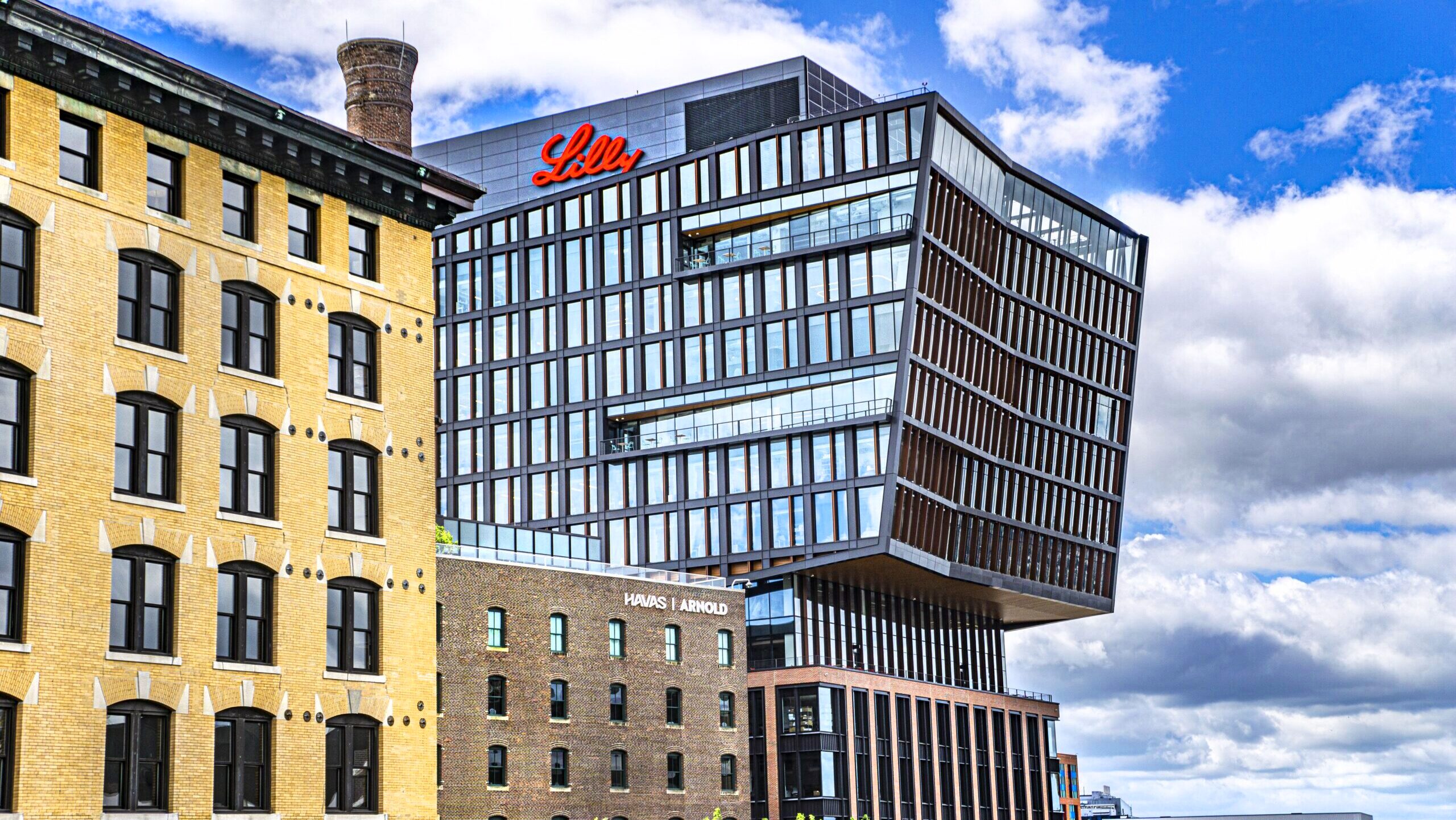 The exterior of the Lilly Seaport Innovation Center in Boston is shown against bright, cloudy sky.
