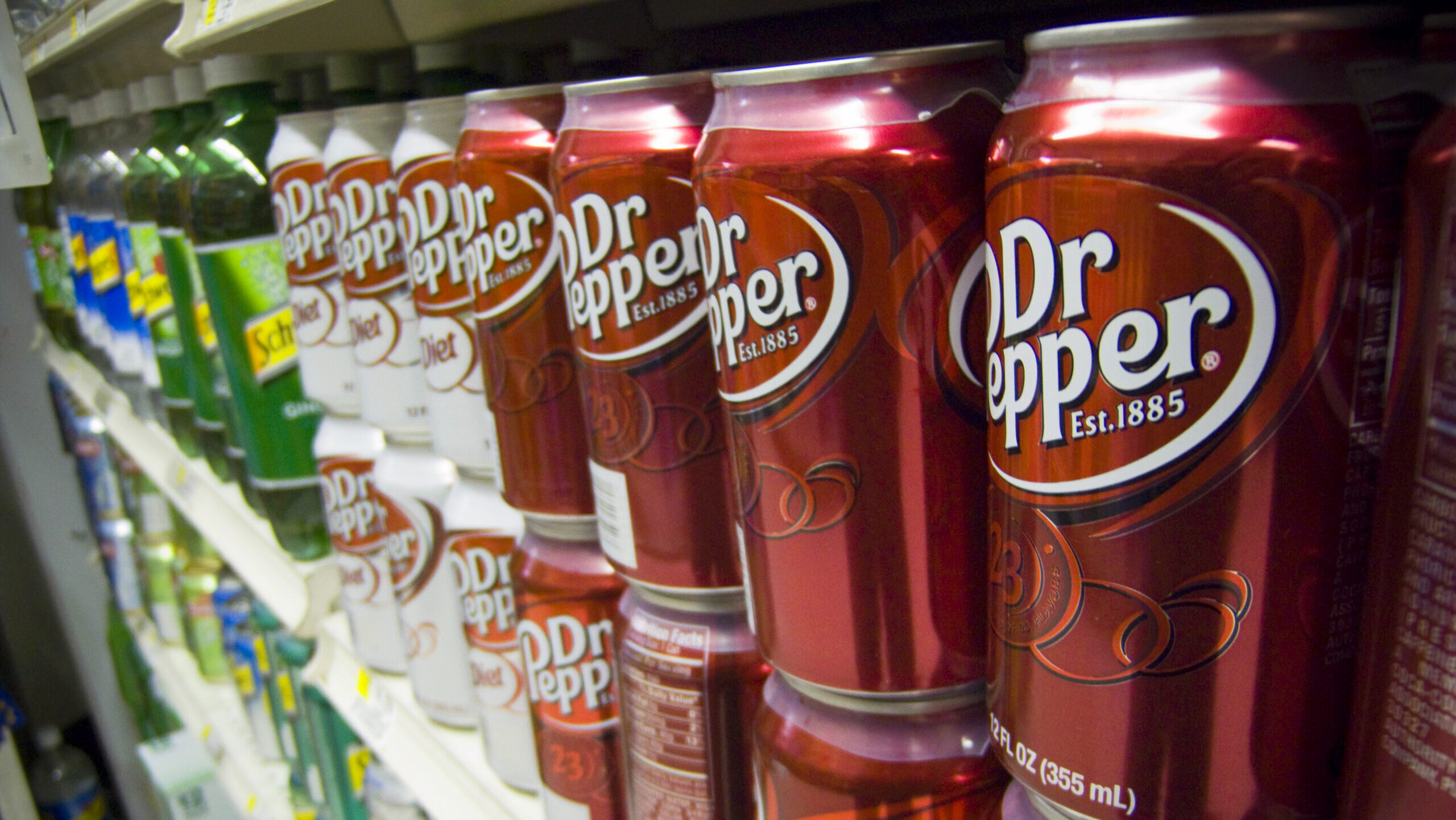 Photo of Dr. Pepper soda cans on a supermarket shelf.