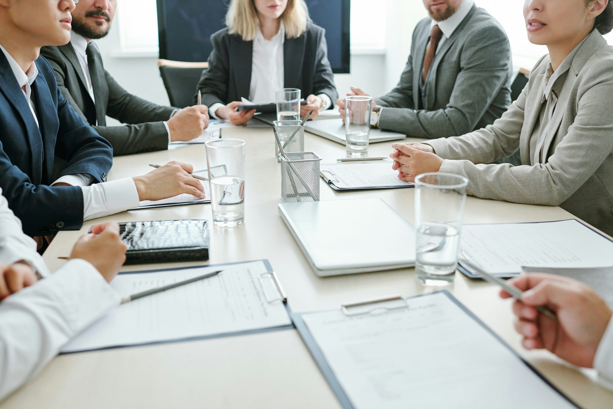 Group of people sitting around a boardroom table.