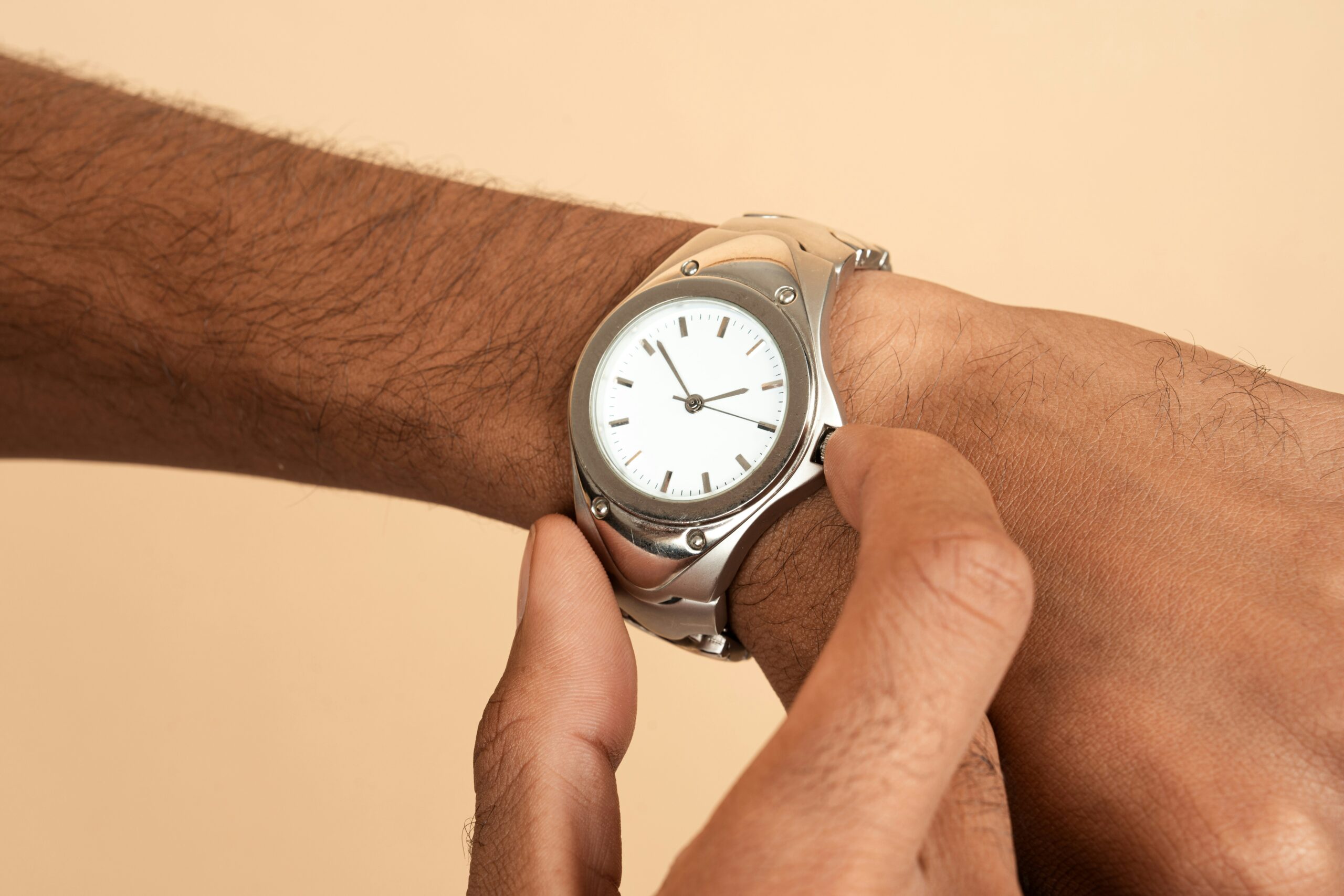 Photo of a person's arm as they are checking a wrist watch.