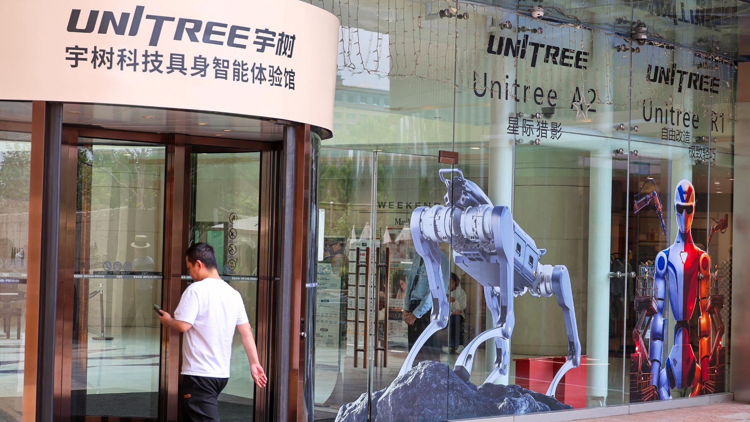 Images of quadripeal and bipedal robots are displayed on a Unitree Robotics office in Shanghai.
